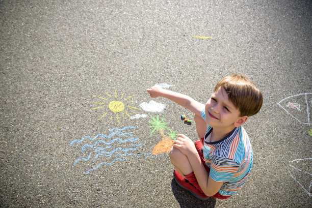 海的梦想。可爱的微笑的男孩站在他的手，感到高兴，同时梦想着在夏天去海边旅游和观察奇妙的船只图片下载