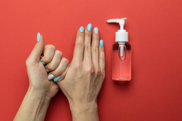 洗手时双手隔离红色。在红色背景的实验室手套中使用医用消毒剂凝胶。在泵瓶中放入清洁消毒剂。清洁手卫生，预防冠状病毒爆发图片下载