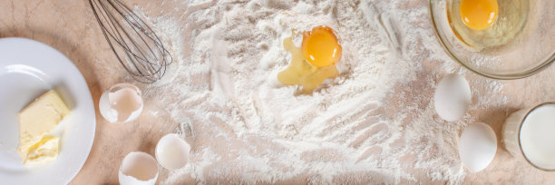 厨房的桌子上有烹饪和烘烤的配料。副本的空间。烹饪概念。鸡蛋，面粉做背景。面团配料。横幅。图片下载