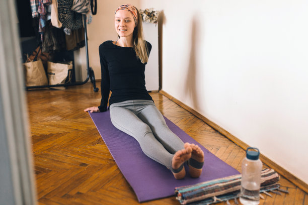年轻女子在家里做瑜伽练习图片下载