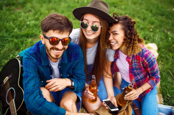 一群朋友享受聚会，喝着啤酒，笑着。图片下载