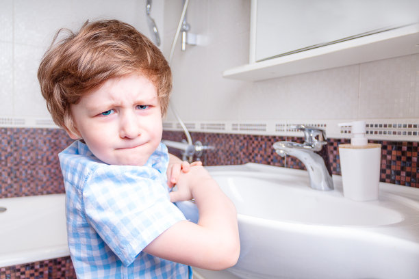 一个生气的可爱小男孩在浴室里看着你让你洗手图片下载