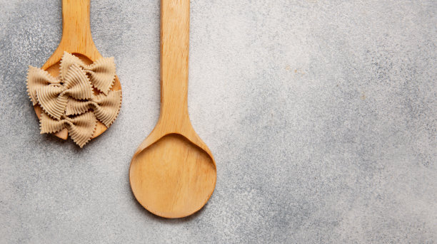 生的彩色意大利面在木制勺子上的混凝土背景。副本的空间。从上面看。图片下载