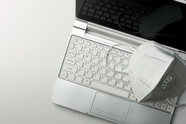 在笔记本电脑上佩戴在家工作的健康口罩图片下载