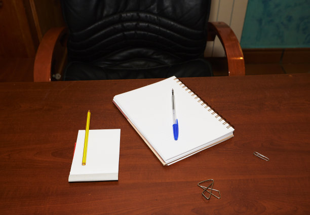 棕色的书桌桌上有笔记本，钢笔，红剪刀，彩色铅笔图片下载