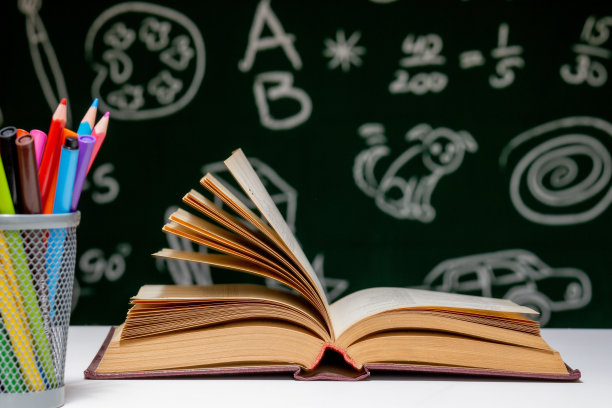 回到学校背景与书籍，铅笔和地球灯在白色的桌子上，在绿色的黑板背景。图片下载