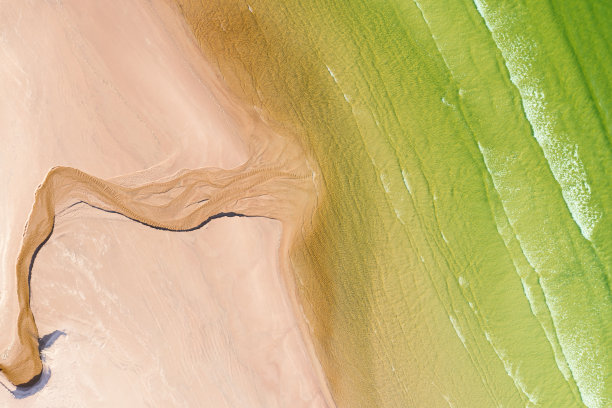 江流入海俯视图。色彩鲜艳的水、沙滩。美丽的背景。图片下载