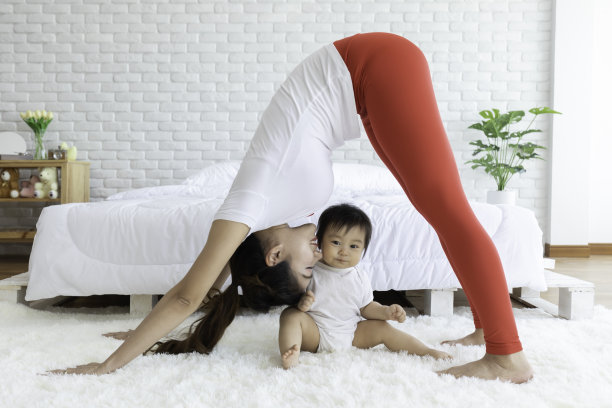 美丽的亚洲女性早上醒来后在卧室里和宝宝练习瑜伽冥想，感觉如此舒适和放松，瑜伽和宝宝的保健理念图片下载