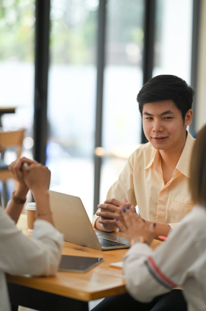 在舒适的会议室背景下，坐在木制办公桌前的商业开发团队一起讨论/开会/讨论的照片。协作的概念。图片下载