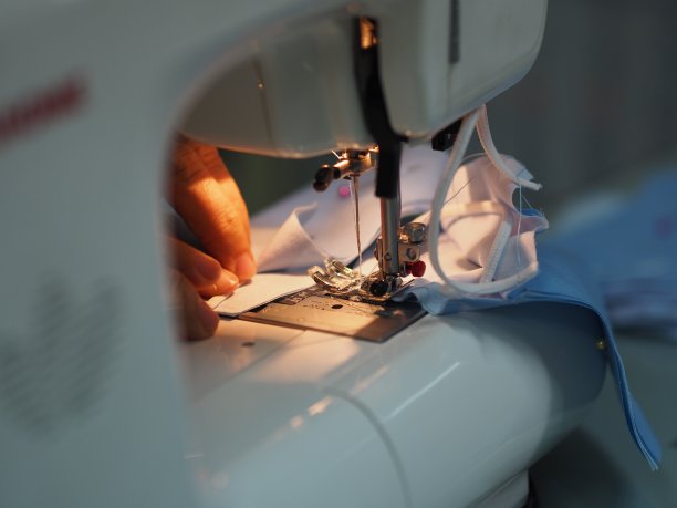 妇女用缝纫机缝制医用口罩，以保护在灰尘PM 2.5、冠状病毒疫情、新冠病毒工作期间在家自制的DIY图片下载