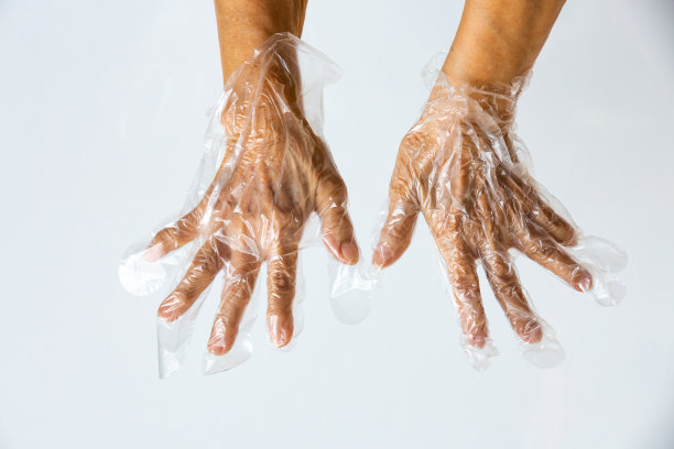 灰色背景，老妇手戴一次性塑料防护手套，特写，预防新冠肺炎，冠状病毒，细菌，医疗保健图片下载