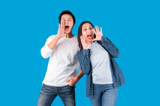 亚洲夫妇男女大声呼喊和宣布与蓝色背景与拷贝空间图片下载