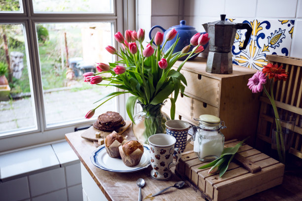 静物-美丽的粉红色郁金香在花瓶与纸杯蛋糕和饼干在老式厨房"n图片下载