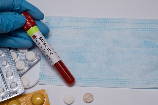 冠状病毒血液检测阳性。医学研究带血的试管医用口罩注射器药丸冠状病毒爆发和流感。2019 - ncov covid-19,非典。高质量的照片。图片下载