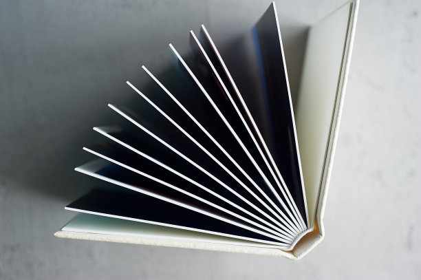 在灰色混凝土背景上硬皮革封面的相册。制作照片并存储它们。昂贵装帧的婚礼相册或书图片下载