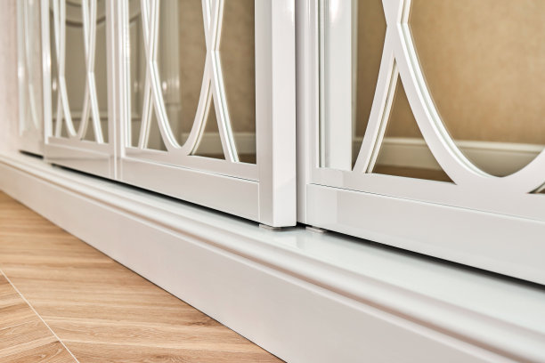 滑动镜衣柜门与覆盖装饰。镶木地板背景上的白色滑动镜衣橱图片下载