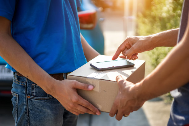 亚洲快递员戴着口罩送包裹，顾客戴着医用手套在药片上签名。隔离、疾病爆发、冠状病毒新冠肺炎大流行情况下的配送服务。图片下载