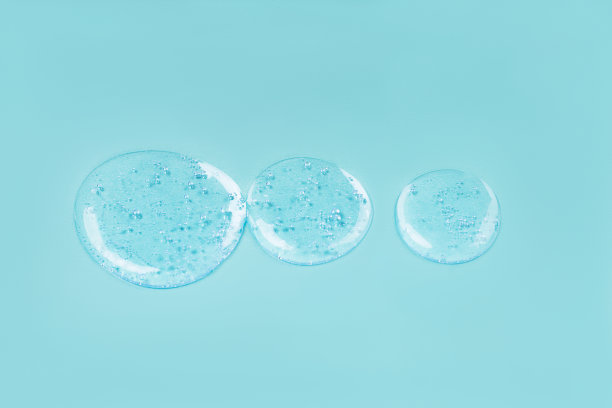 医用滴管和透明质脂滴在蓝色背景上。图片下载