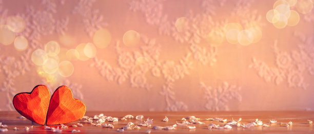 婚礼和情人节的纹理背景。一种明亮纯洁的爱的感觉。两颗带有白色花瓣的红心和蕾丝背景图片下载