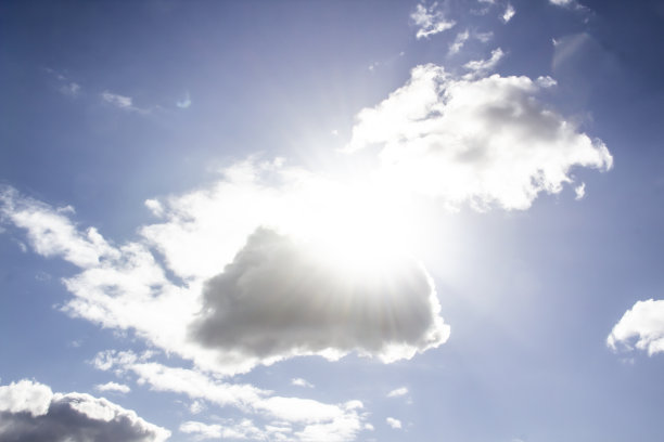 蓝天上的云朵带着太阳的光芒。一个奇迹，上帝的光芒映衬着背景。图案来自天空中的云。图片下载