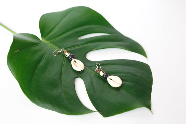 用珠子和贝壳做成的耳环放在男被单上图片下载