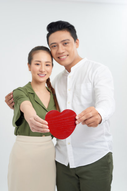 一个年轻的情侣抱着红色的心的全身图片图片下载