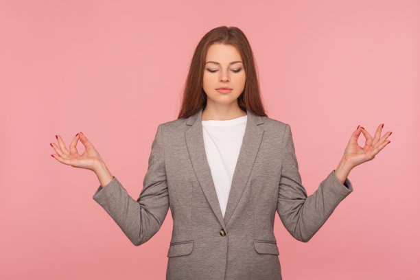 精神控制，瑜伽练习。年轻女子的肖像在商务套装沉思与合十礼手势图片下载