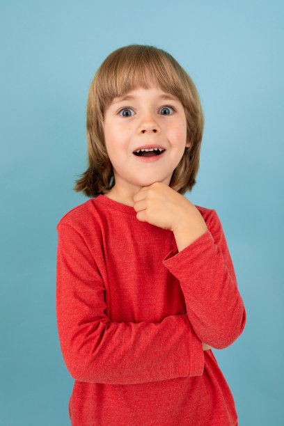 一个十几岁的白人男孩在红色夹克有一个伟大的想法，图片孤立在蓝色的背景图片下载