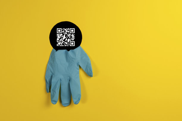 一次性医用手套蓝色透过黑洞在黄色背景。保持安全。关于隔离的概念和引入通行证或二维码出境的房子。本空间图片下载