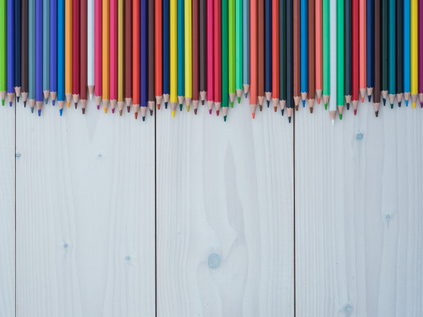 在木制背景上排成一排的一套彩色铅笔图片下载