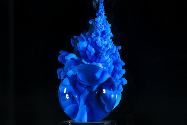 在水下和黑色背景上有蓝色喷漆的玻璃球图片下载