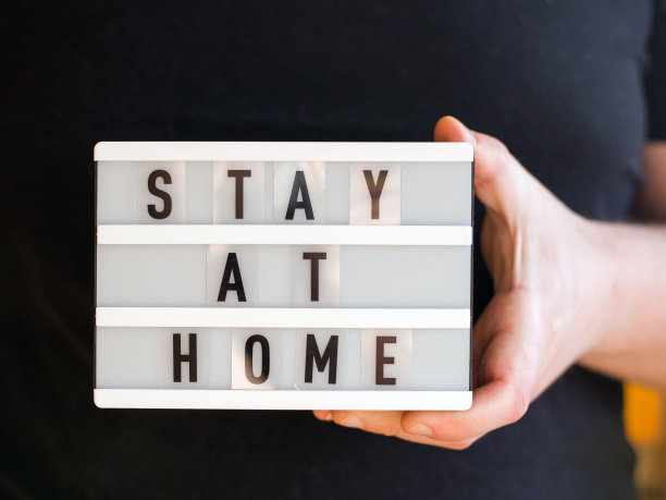医生男双手显示文字呆在家里的白色灯箱上。停止冠状病毒。检疫在家里。COVID 2019图片下载