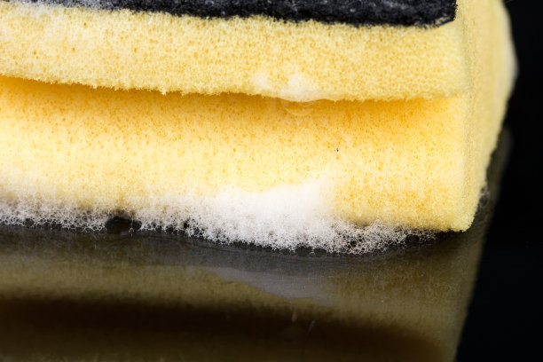 海绵洗碗用洗涤剂泡沫在黑色的背景反射图片下载