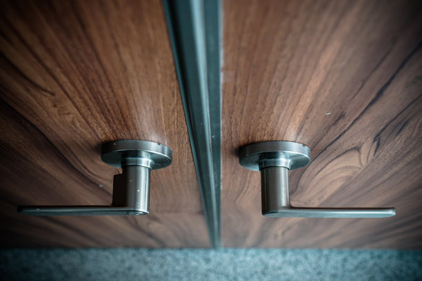 棕色木门与金属门把手和锁。在看。图片下载