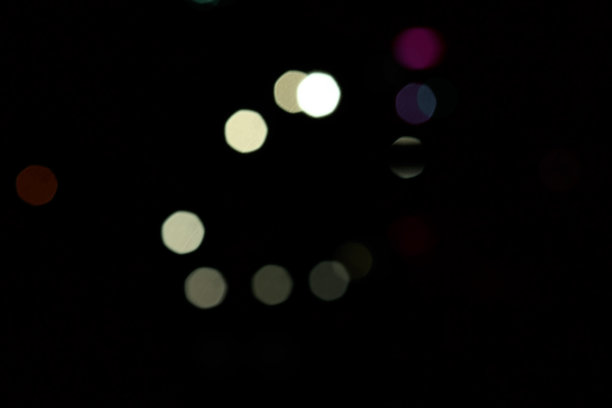 彩色的圆形散景模糊灯光在黑暗的背景图片下载