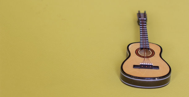 黄色背景上的吉他乐器图片下载