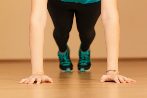 一张年轻女子在家做俯卧撑的照片图片下载