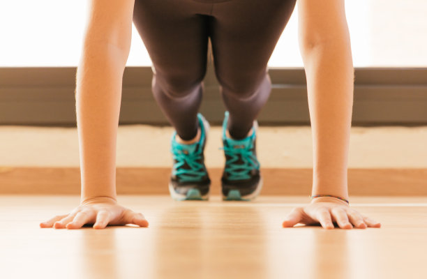 一张年轻女子在家做俯卧撑的照片图片下载