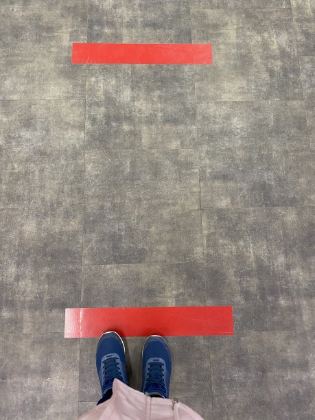 有人站在有红线的地砖上。保持距离、社交距离、隔离或隔离的概念图片下载