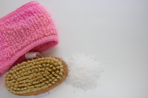 海盐，毛巾，身体按摩刷上白色背景图片下载