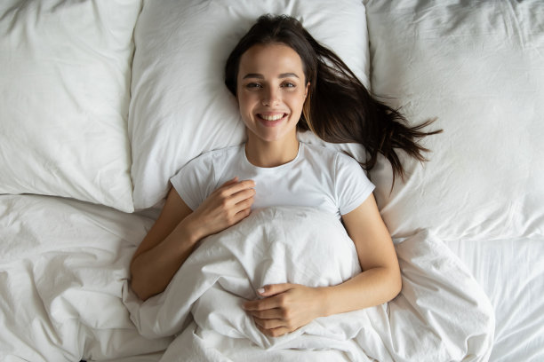 快乐的女孩躺在床上，早上醒来图片下载