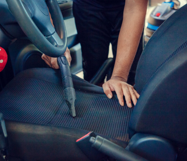 洗车工人用吸尘器清洗汽车内部图片下载