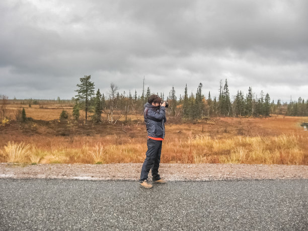 一位中年妇女站在路中间拍照。旅游的概念图片下载
