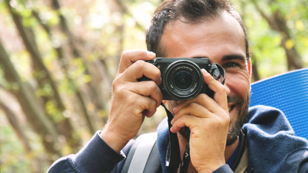 在阳光明媚的日子里，在树林里的人拍下照片，呼吸着纯净的空气图片下载