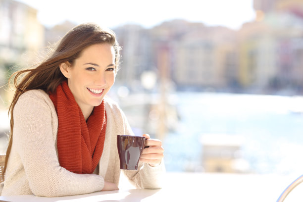 快乐的游客拿着咖啡杯看着相机图片下载