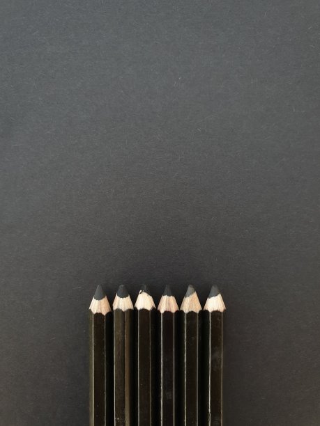 黑色背景上的一组黑色铅笔，指向上方。有写字的空间。可用作模板、墙纸、演示文稿、小册子或公司信息。图片下载
