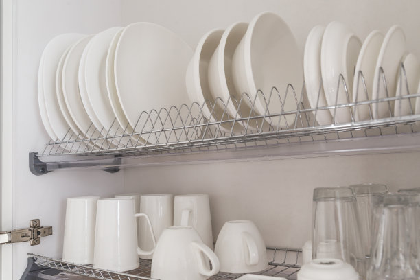 盘子烘干金属架与大漂亮的白色干净的厨房用具。传统壁柜厨房图片下载