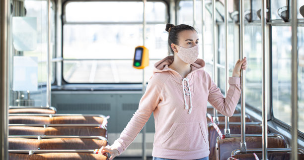 一名年轻女性在疫情期间乘坐公共交通工具。图片下载