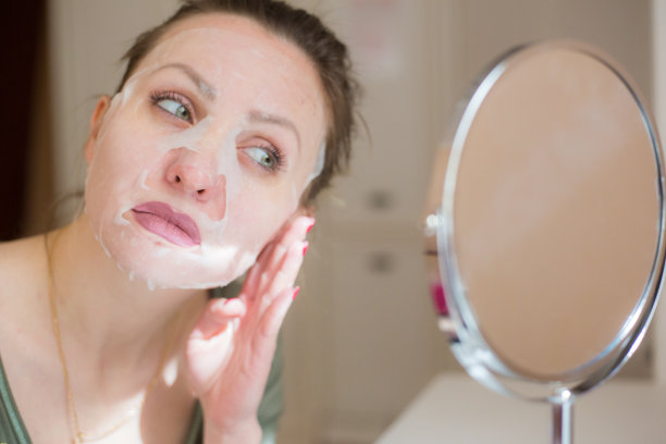 化妆面膜和女孩照镜子图片下载