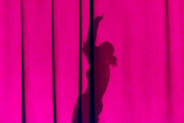 窗帘上女性的剪影。图片下载